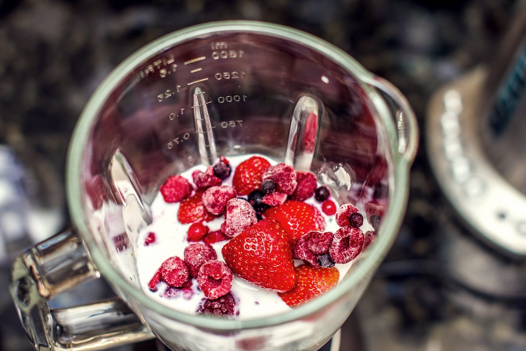 Assortment of soft foods recommended after oral surgery including berries, yogurt, and smoothies